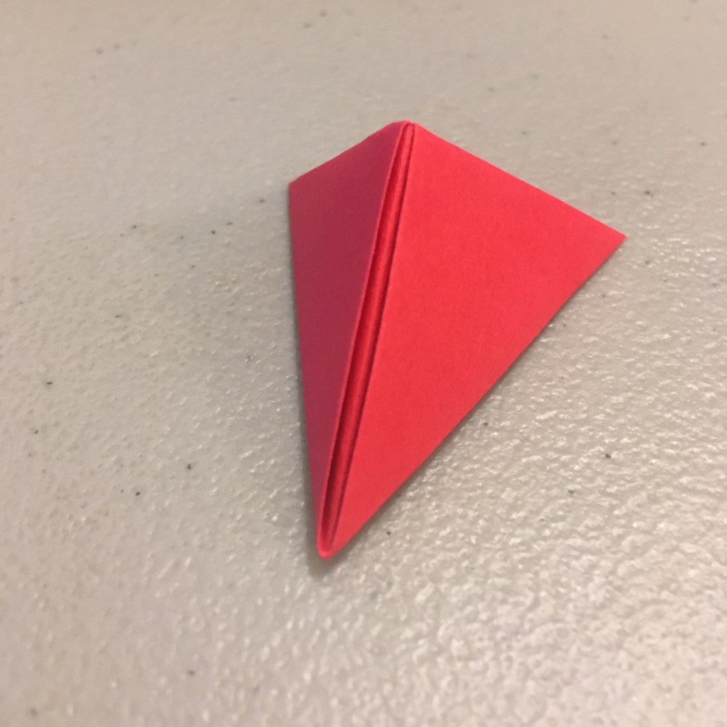 A red piece of paper folded into a triangular shape.